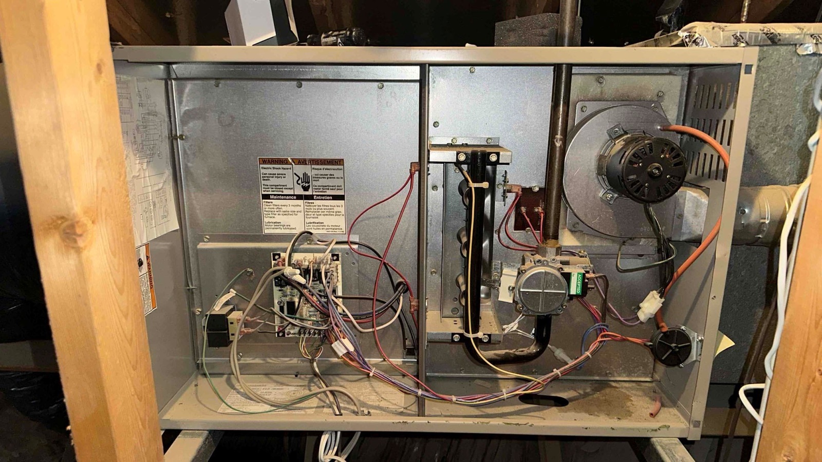 Open residential furnace cabinet showing internal controls and components